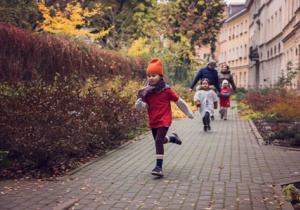 Dzieci biegną chodnikiem